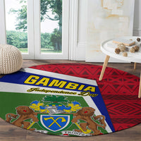 Round carpet showing Gambia coat of arms crest over red and blue geometric background