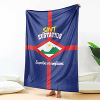 Blue Sint Eustatius flag fleece blanket draped with red cross and 'Superba et confidens'.