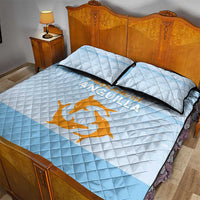 Light blue quilt with diamond quilting, two pillowcases, and orange anchor-and-wave emblem.