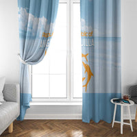 Blue window curtains with gold animal print, side curtains gathered at a window.