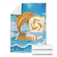 Anguilla blanket, blue with orange dolphin emblem and waves, folded with white towels