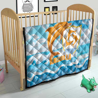 Blue quilt blanket on toddler bed with orange Anguilla dolphin emblem and wave print