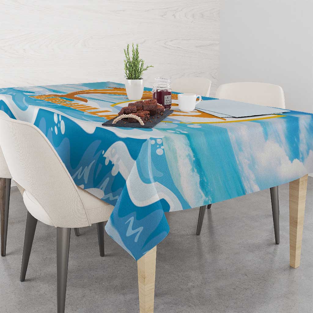 Blue tablecloth draped on a dining table, featuring orange and gold dolphin and waves.