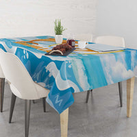 Blue tablecloth draped on a dining table, featuring orange and gold dolphin and waves.