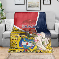Colombia Independence Day blanket on gray couch, red-navy top with floral emblem art