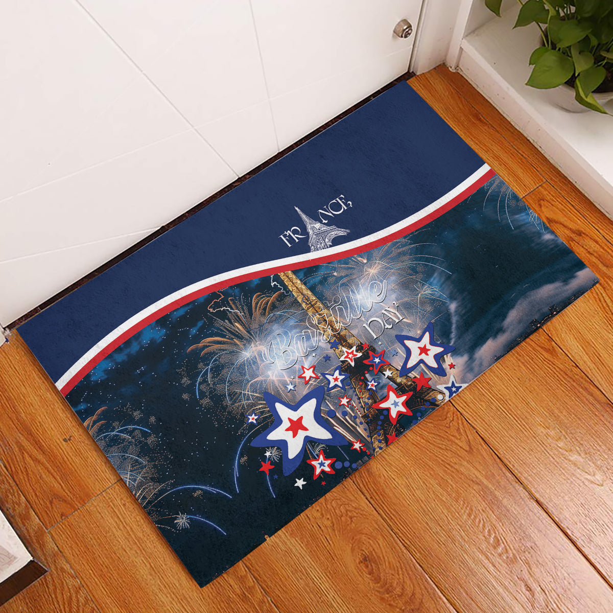 Blue rubber doormat with fireworks, star shapes, and French tricolor stripe near Eiffel tower graphic.