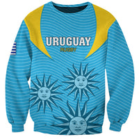 Blue rugby sweatshirt with yellow trim, Uruguay Rugby text, sun-face graphic