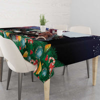 Rectangular Christmas tablecloth draped on table, dark base with pine and bell motifs