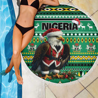 Round green beach blanket with Nigeria eagle Santa design and white fringe border by pool.