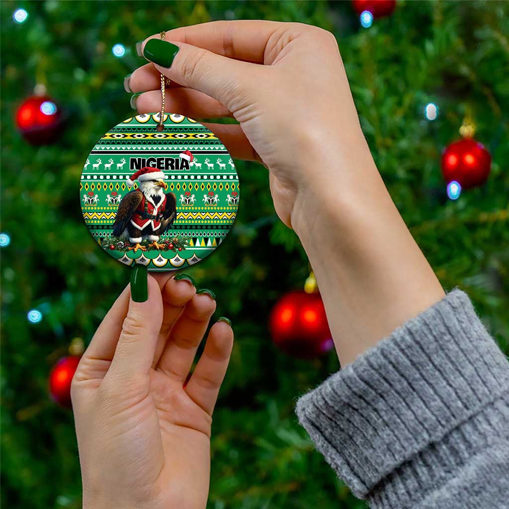 Green ceramic round ornament with Nigeria pattern and Santa figure, held by hand with gold loop