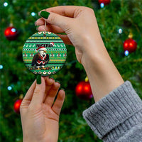 Green ceramic round ornament with Nigeria pattern and Santa figure, held by hand with gold loop