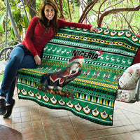 Green quilt laid out on a couch with Eagle Santa, Nigeria text, reindeer silhouettes, and borders