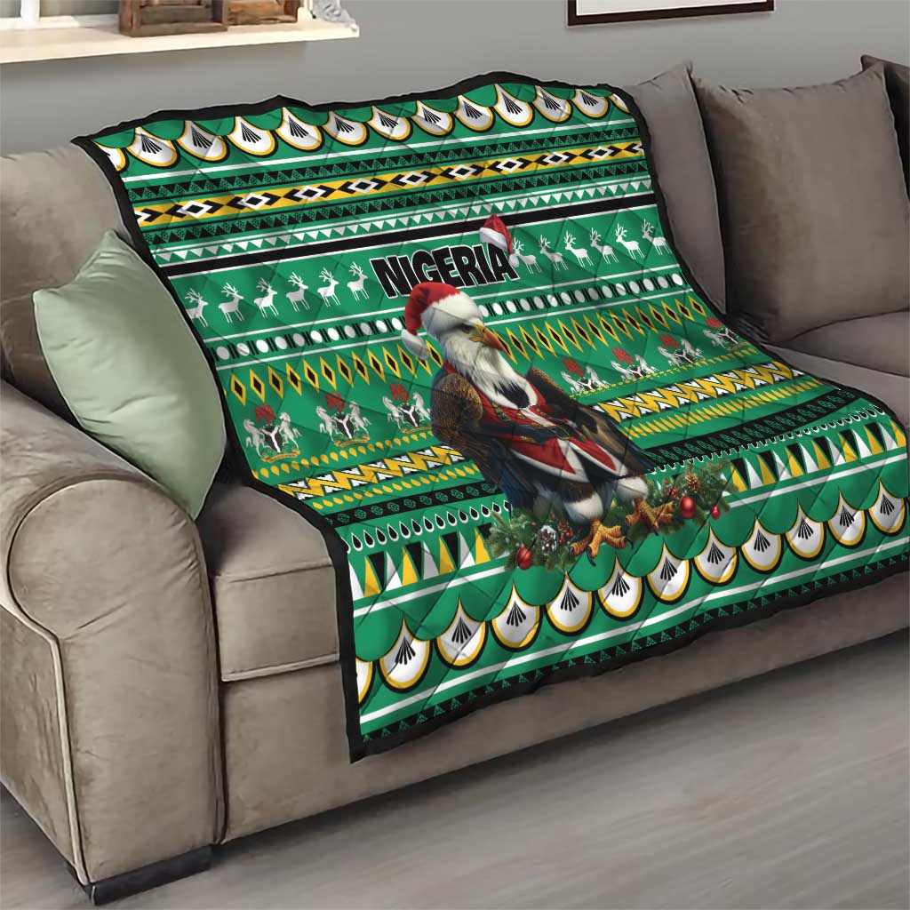 Green throw quilt on a couch with Eagle Santa, Nigeria lettering, reindeer motifs, and repeating patterns
