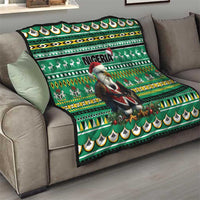 Green throw quilt on a couch with Eagle Santa, Nigeria lettering, reindeer motifs, and repeating patterns