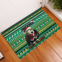 Green rubber doormat with Nigeria text, eagle wearing Santa hat, and African holiday motif border