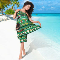 Green patterned sarong with Santa and animal motifs, draped across the body