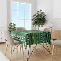 Green patterned tablecloth with scalloped edge and geometric motifs on dining table