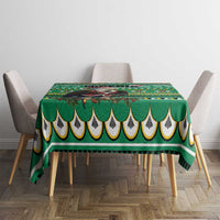 Green tablecloth with scalloped hem and multicolor geometric pattern on dining table