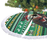 Green round tree skirt with eagle-and-Santa African pattern and white fringe border