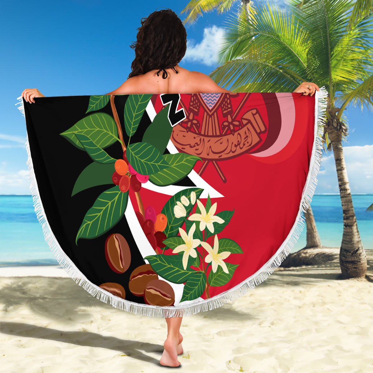 Round beach blanket held on sand, Yemen unification flag design with fringed edge