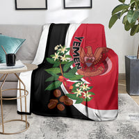Red and black Yemen flag-style blanket on couch, white curves and crest graphics.