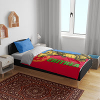 Bedding set on bed: blue pillow, red duvet with yellow camel graphic and green lettering