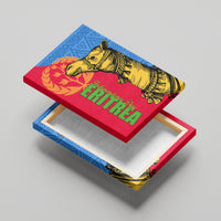 Close angled view of canvas wall art with yellow camel, green red text, and blue patterned top
