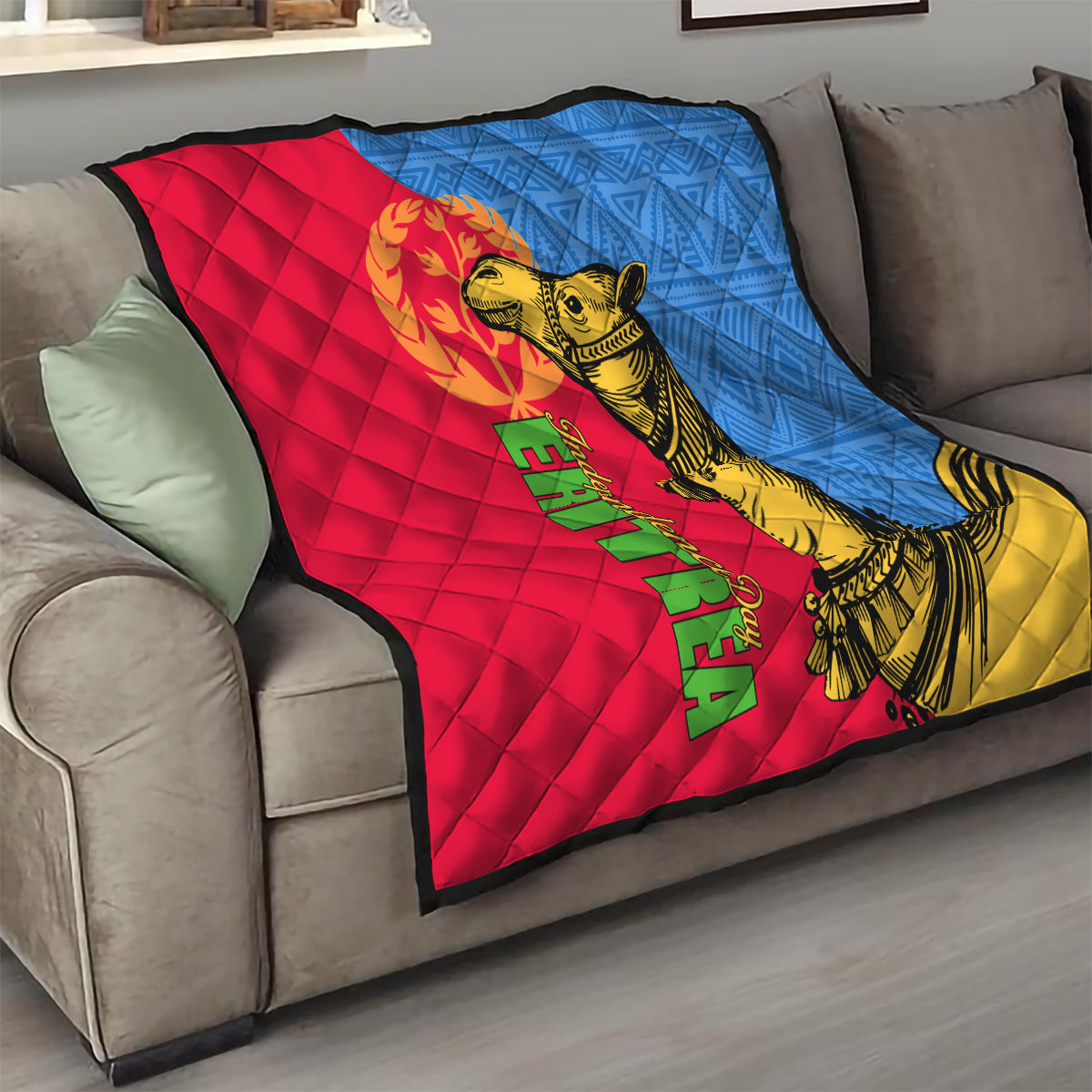 Quilt draped on sofa in red, blue, and yellow with golden camel and Eritrea lettering.