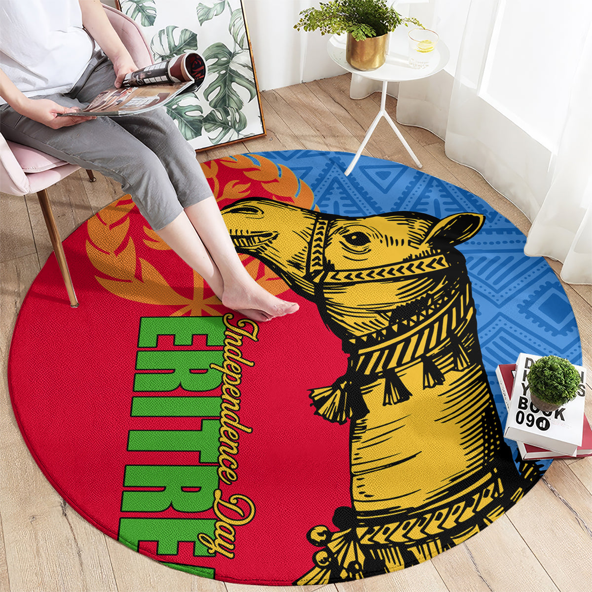 Round area rug with red, blue, and yellow pattern featuring camel artwork and green text