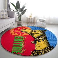 Round area rug showing a yellow camel figure on red with blue accents and green lettering