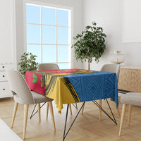 Eritrean camel tablecloth in red, yellow, and blue on dining table with chairs