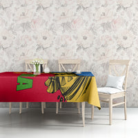 Red, yellow, and blue camel patterned tablecloth on table against light floral wall