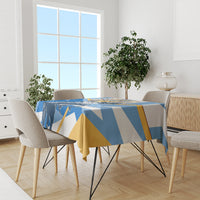 Blue patriotic tablecloth with sun-and-banner artwork on dining table with chairs