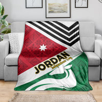 Jordan folk pattern throw blanket draped over couch with red star triangle and green emblem