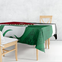 Green tablecloth with red and white folk flag pattern, black zigzag border, rectangular fit
