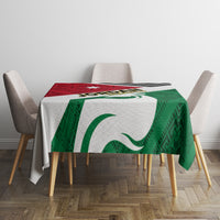 Green and red folk flag tablecloth with large white emblem, geometric borders, corner prints