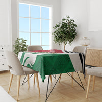 Green flag-style tablecloth with red top stripe and black zigzag border on dining table