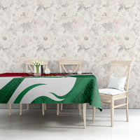 Green tablecloth with large white emblem and geometric folk print, red top stripe