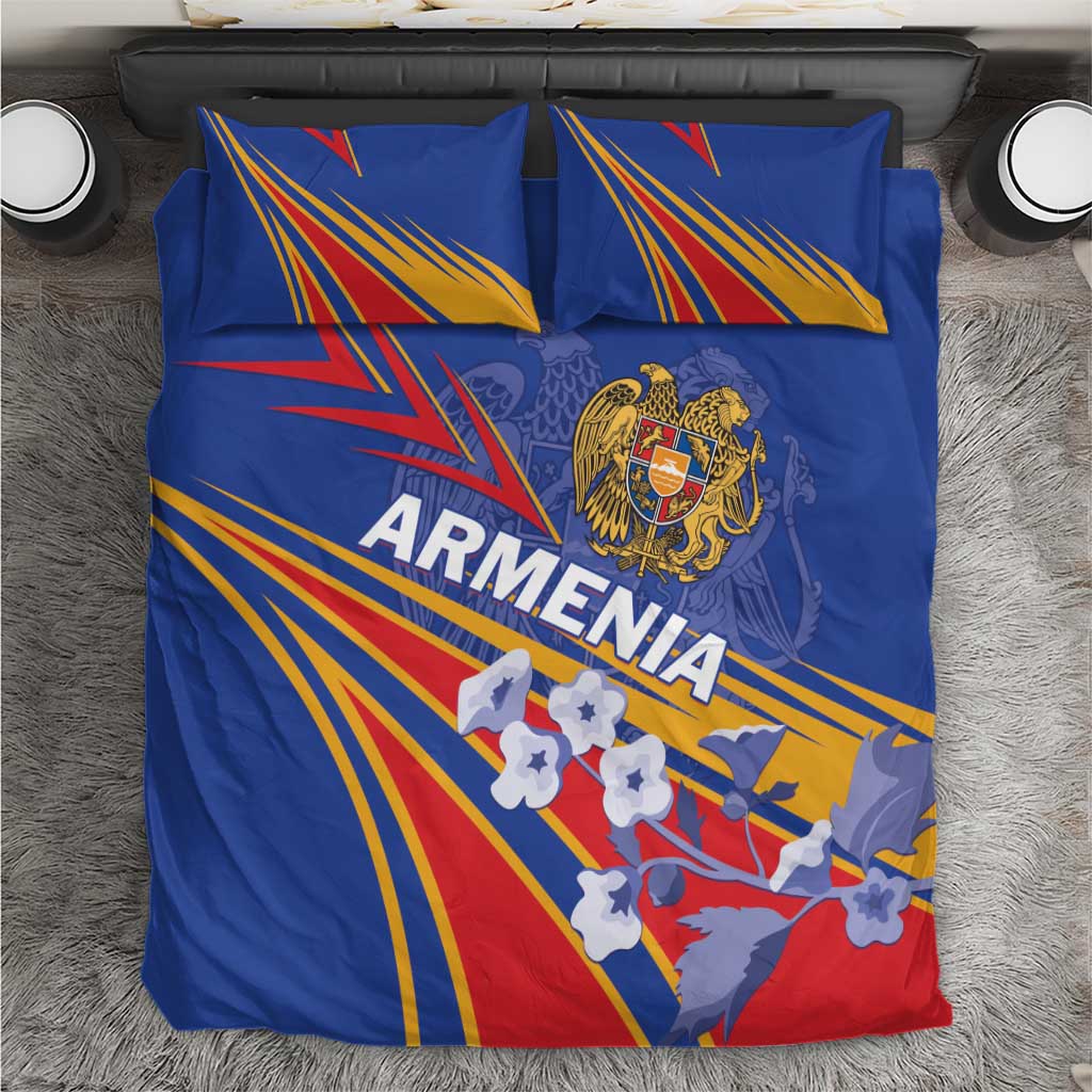 Blue bedding set on bed with two pillows; Armenia lettering, crest, and stripe fan artwork
