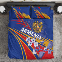 Blue bedding set on bed with two pillows; Armenia lettering, crest, and stripe fan artwork