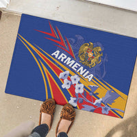 Blue rubber doormat showing Armenia crest, rays in red yellow blue, and flower accents