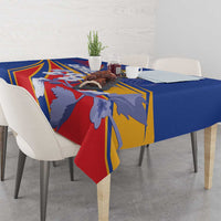 Blue tablecloth draped on dining table with colorful Armenia-inspired centerpiece pattern.