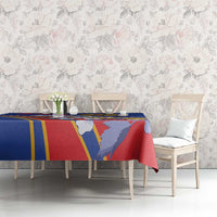 Blue tablecloth with red and yellow stripes and illustrated figures over dining table.
