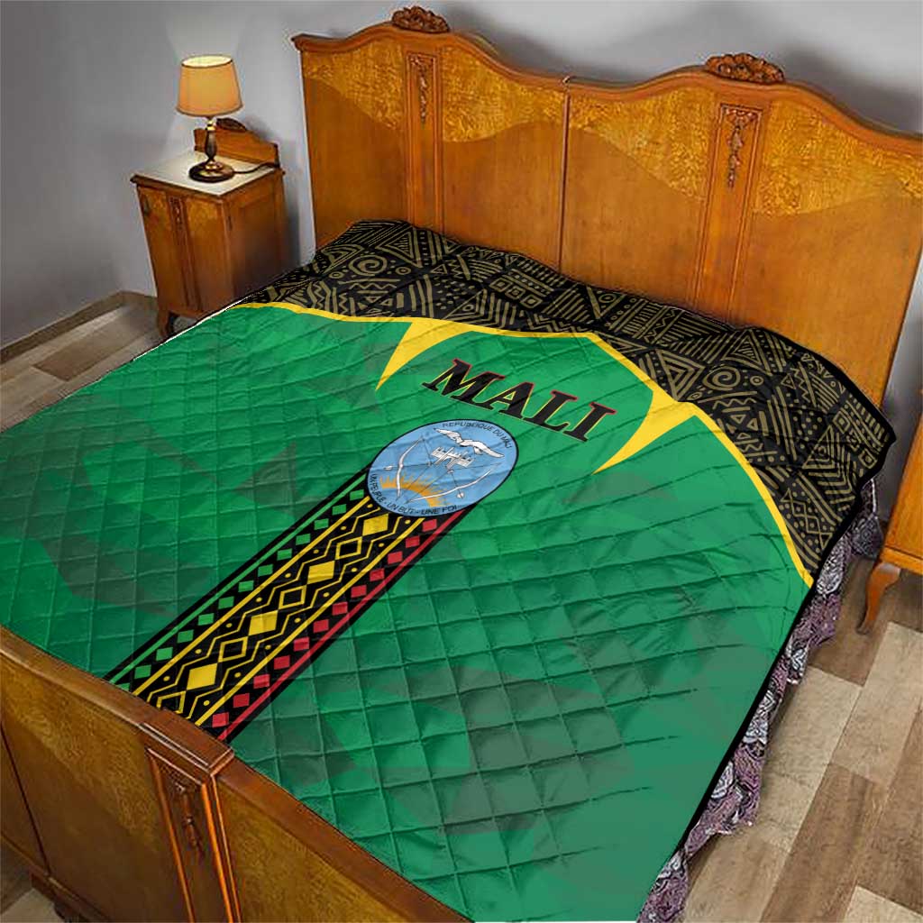 Mali green quilt on bed with black border, yellow star, and Mali crest