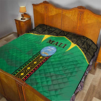 Mali green quilt on bed with black border, yellow star, and Mali crest