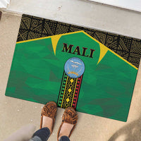Rectangular green Mali rubber doormat with centered emblem; brown shoes near the edge