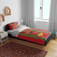 Red bedding set on bed with green emblem panel, black star, and decorative wreath