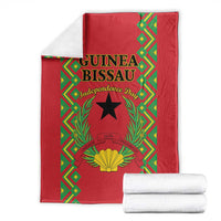 Red folded blanket with Guinea-Bissau Independence Day artwork, black star and golden shell
