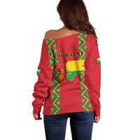 Women’s red off-shoulder sweater with green back graphic and long sleeves