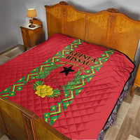 Red quilted bedding throw on bed with Guinea-Bissau crest and green vine border